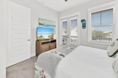 a bedroom with a bed and a flat screen tv at Town of Prominence 80C- The Wright Place in Santa Rosa Beach