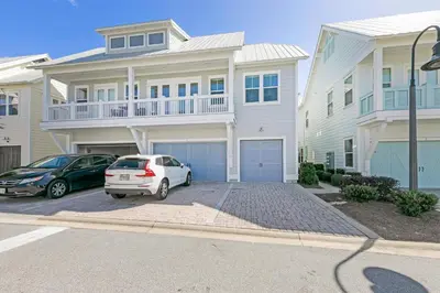 a white house with two cars parked in a parking lot at Town of Prominence 80C- The Wright Place in Santa Rosa Beach