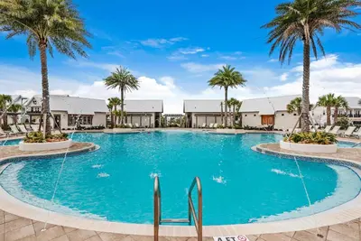 a large swimming pool with palm trees in a resort at Town of Prominence 80C- The Wright Place in Santa Rosa Beach