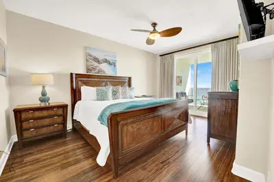 a bedroom with a bed and a balcony with the ocean at Ocean Ritz 1203 in Panama City Beach