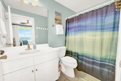 a bathroom with a toilet and a shower curtain at Ocean Ritz 1203 in Panama City Beach