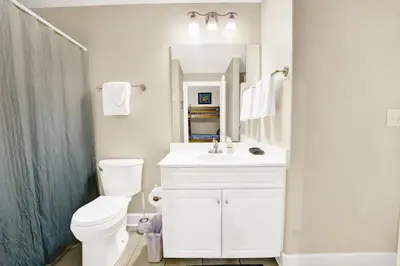a bathroom with a toilet and a sink and a mirror at Ocean Ritz 1203 in Panama City Beach