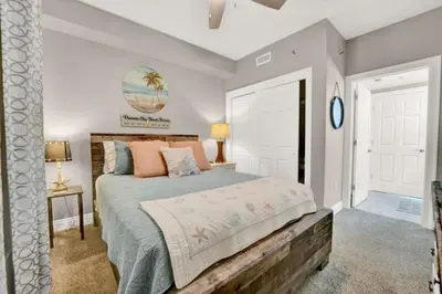 a bedroom with a large bed with a wooden headboard at Gulfcrest 206 in Panama City Beach