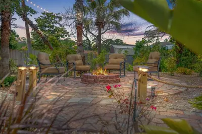 a patio with chairs and a fire pit in a yard at Shipwrecked - Private Pool Home, Game Room, 5 Min to Beach, Pets OK, & More! in Panama City Beach