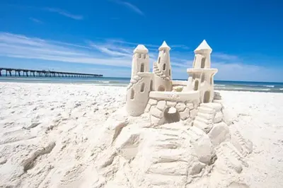 a sand castle on a beach next to the ocean at Shipwrecked - Private Pool Home, Game Room, 5 Min to Beach, Pets OK, & More! in Panama City Beach