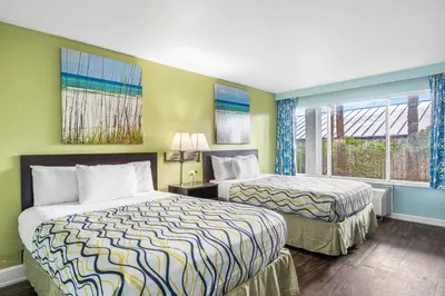 a hotel room with two beds and a window at Boardwalk Beach Hotel in Panama City Beach