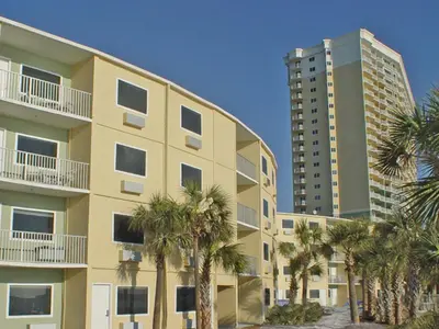 a tall building with palm trees in front of it at Boardwalk Beach Hotel in Panama City Beach