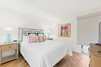 a white bedroom with a bed and a television at Edgewater Beach Resort #207 Tower 2 by Book That Condo in Panama City Beach
