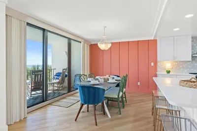 a kitchen and dining room with a table with blue chairs at Edgewater Beach Resort #207 Tower 2 by Book That Condo in Panama City Beach