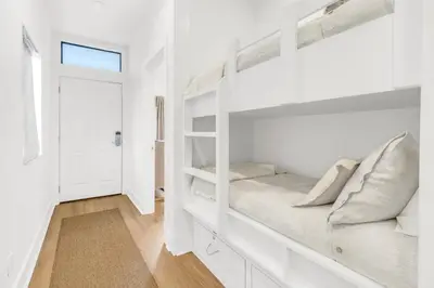 a bedroom with white bunk beds and a window at Psalms in Santa Rosa Beach