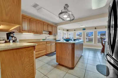 a large kitchen with wooden cabinets and a island in it at Luxury Bathroom Home with Game Room 25 Mins to PCB in Panama City