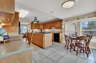 a kitchen with wooden cabinets and a table and chairs at Luxury Bathroom Home with Game Room 25 Mins to PCB in Panama City