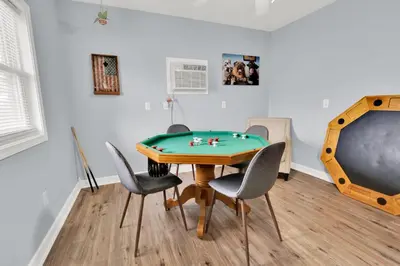 a room with a ping pong table and chairs at Luxury Bathroom Home with Game Room 25 Mins to PCB in Panama City