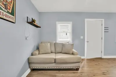 a couch in a living room with white walls at Luxury Bathroom Home with Game Room 25 Mins to PCB in Panama City