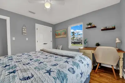 a bedroom with a bed and a desk and a chair at Luxury Bathroom Home with Game Room 25 Mins to PCB in Panama City