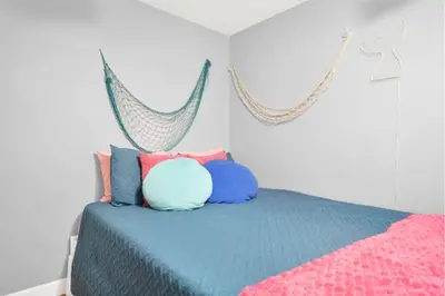 a bedroom with a bed with colorful pillows at Luxury Bathroom Home with Game Room 25 Mins to PCB in Panama City