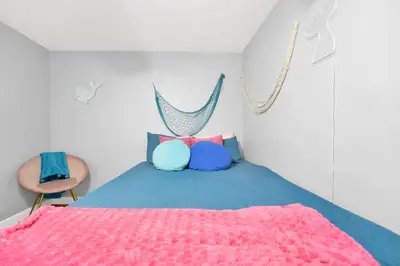 a bedroom with a bed with a pink blanket at Luxury Bathroom Home with Game Room 25 Mins to PCB in Panama City