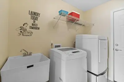 a laundry room with a sink and a washing machine at The Splash Pad Sleeps 13 w Pool Patio and Garage in Panama City