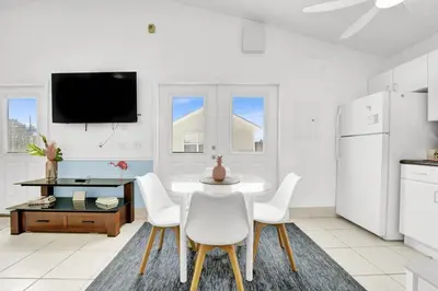 a white kitchen with a table and chairs at The Splash Pad Sleeps 13 w Pool Patio and Garage in Panama City