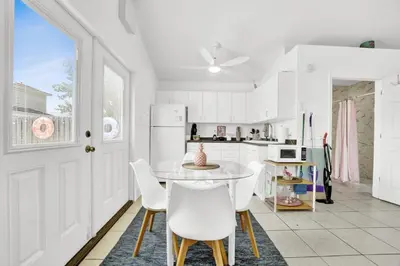 a white kitchen with a table and chairs at The Splash Pad Sleeps 13 w Pool Patio and Garage in Panama City