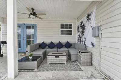 a patio with a couch and a ceiling fan at The Splash Pad Sleeps 13 w Pool Patio and Garage in Panama City