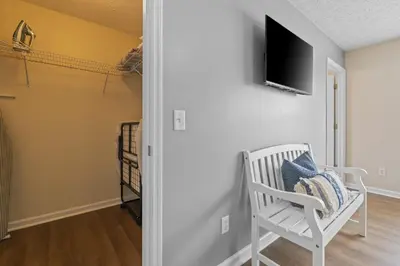 a room with a white chair and a television on a wall at Escape to Paradise w Saltwater Pool 25 Min to PCB in Panama City