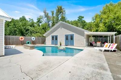 a backyard with a swimming pool and a house at Escape to Paradise w Saltwater Pool 25 Min to PCB in Panama City