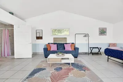 a living room with a blue couch and a table at Luxe Pool Casita w Saltwater Pool 25 Min to PCB in Panama City