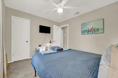 a bedroom with a bed and a ceiling fan at Modern Getaway North of Panama City Beach in Panama City