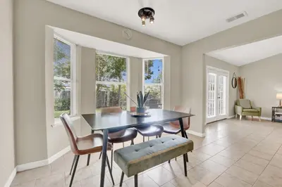 a dining room with a table and chairs and windows at Modern Getaway North of Panama City Beach in Panama City