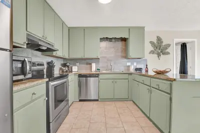 a kitchen with mint green cabinets and appliances at Modern Getaway North of Panama City Beach in Panama City