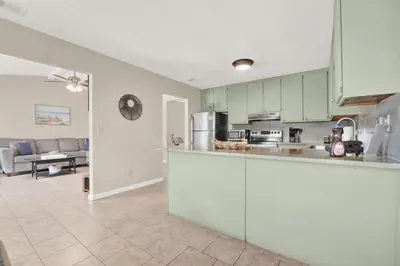 a kitchen with a counter and a living room at Modern Getaway North of Panama City Beach in Panama City