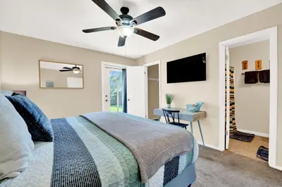 a bedroom with a bed and a ceiling fan at Modern Getaway North of Panama City Beach in Panama City