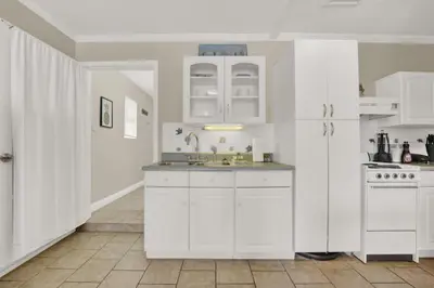 a kitchen with white cabinets and a sink at Luxe Guest Suite Near The Emerald Coast of PCB in Panama City