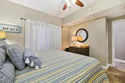 a bedroom with a bed and a window and a mirror at Shores of Panama 1708 condo in Panama City Beach