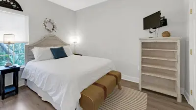 a bedroom with a white bed and a television at KK's Beach House - Newly remodeled, close to Seaside, easy walk to beach in Santa Rosa Beach