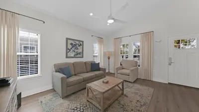 a living room with a couch and a table at Pelican House - Newly remodeled, professionally decorated, only about 1 mile to Seaside! in Santa Rosa Beach