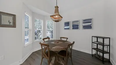 a dining room with a table and chairs and a chandelier at Pelican House - Newly remodeled, professionally decorated, only about 1 mile to Seaside! in Santa Rosa Beach