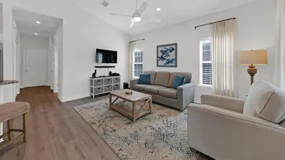 a living room with a couch and a table at Pelican House - Newly remodeled, professionally decorated, only about 1 mile to Seaside! in Santa Rosa Beach