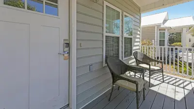 a porch with two chairs and a door at Pelican House - Newly remodeled, professionally decorated, only about 1 mile to Seaside! in Santa Rosa Beach