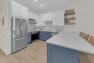 a kitchen with white cabinets and blue appliances at Emerald By Alma - Updated 3BD 2BA condo Seagrove Highlands in Santa Rosa Beach