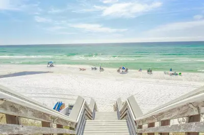 a staircase leading to the beach with people on the sand at Emerald By Alma - Updated 3BD 2BA condo Seagrove Highlands in Santa Rosa Beach