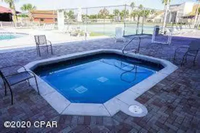 a large swimming pool with chairs and a table at Gulf Views from your 2 private balconies! in Panama City Beach