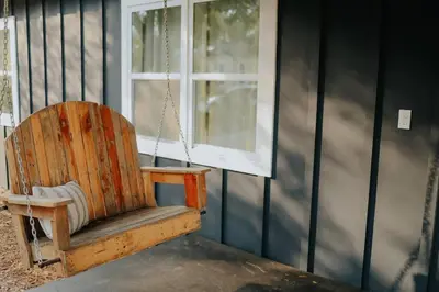 a wooden rocking chair sitting in front of a window at Dream On – Style & Comfort Near Historic Downtown in Panama City