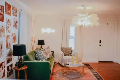a living room with a green couch and a chandelier at Dream On – Style & Comfort Near Historic Downtown in Panama City