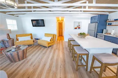 a kitchen and living room with a table and chairs at Conch Cottage in Panama City Beach