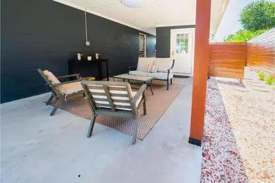 a patio with chairs and a table and a couch at Conch Cottage in Panama City Beach