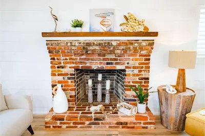 a living room with a brick fireplace at Conch Cottage in Panama City Beach