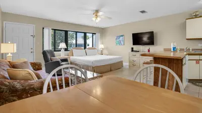 a living room with a table and a kitchen with a couch at Hidden Beach 235 in Santa Rosa Beach