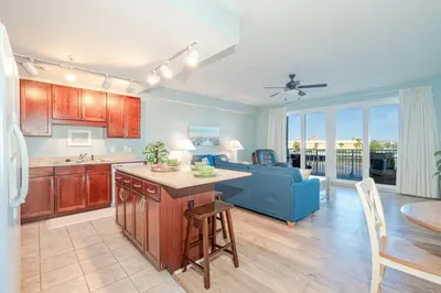 a kitchen and living room with a couch and a table at Laketown Wharf #119 by Nautical Properties in Panama City Beach